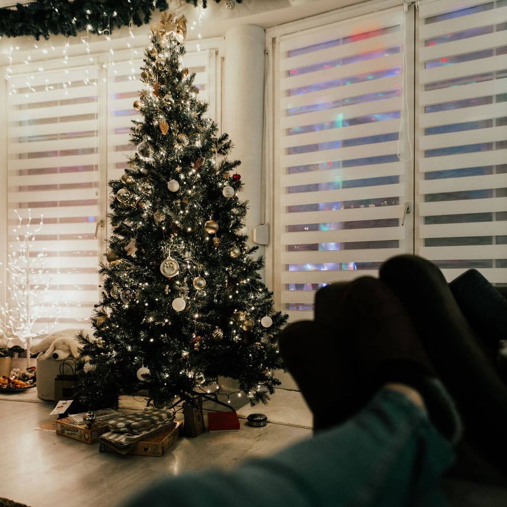 Things to do over Christmas including gold tree with feet up on the sofa to watch a festive film.