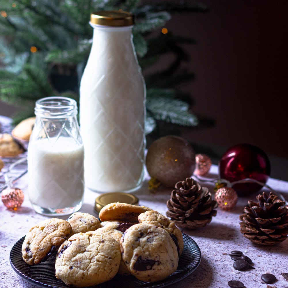 Things to do over Christmas including milk and cookies for Santa. Plate of cookies with jug of milk surrounded by Christmas decorations.